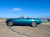 an image of a blue convertible car parked in a parking lot