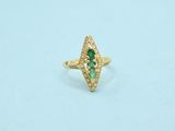 a close up of a gold ring with a green stone