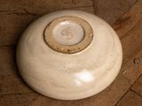 a white vase sitting on a wooden floor on the floor