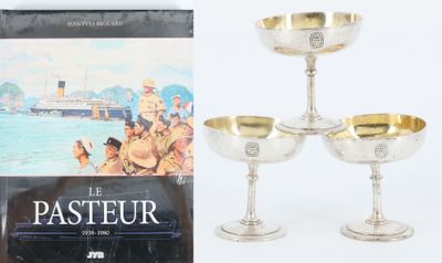 trois verres à vin plaqués argent et un livre sur fond blanc