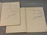 two open notebooks with writing on them sitting on a table