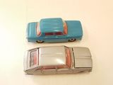 two toy cars that are sitting side by side on a table