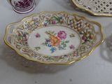 three plates and cups on a table with a vase
