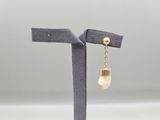 gros plan d'une paire de boucles d'oreilles sur un support