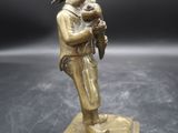 une figurine antique en bronze représentant un homme tenant un bébé dans ses bras