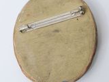 a small wooden pin with a metal pin on it