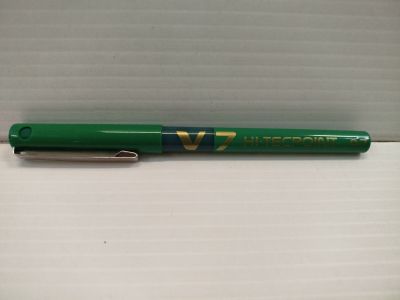 un stylo vert posé sur une boîte blanche