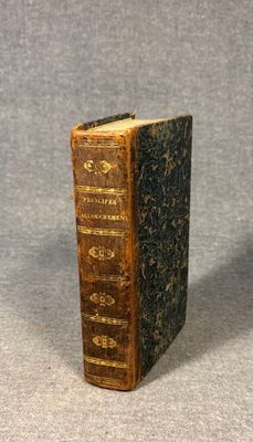 an old book sitting on top of a table next to a gray background