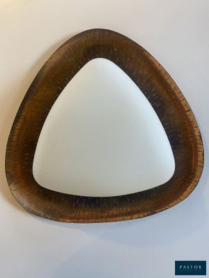 a triangle shaped mirror hanging on the wall