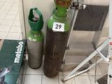 two propane gas bottles on the floor next to a ladder