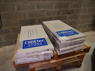 deux caisses de béton posées sur une palette devant un mur de briques