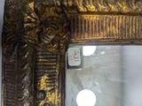a mirror with a gold frame on the wall
