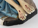 a figurine of a woman with blood on her hands