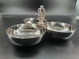 two silver bowls on a black table with a silver spoon