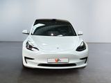 a white tesla model s parked in a white room