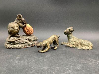 trois figurines d'animaux et une souris posée sur un rocher