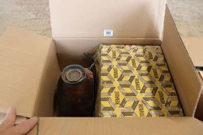 Quelqu'un ouvre une boîte contenant une boisson, posée par terre.