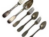 five spoons and a fork on a white surface