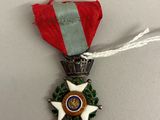 la médaille est accrochée à un ruban rouge orné d'une étoile blanche