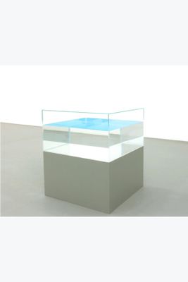 a glass display case with a blue pool inside of it