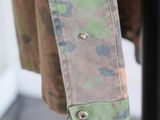 a close up of a military jacket hanging on a rack