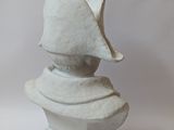 a white sculpture of a hat on top of a pedestal