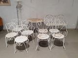 several chairs and a table in a room with a painting on the wall
