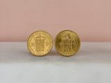 a pair of gold coins sitting on top of a marble counter