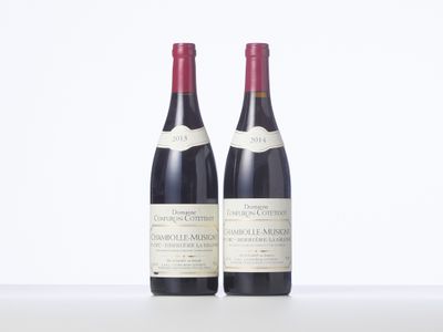 two bottles of wine sitting on top of a white table