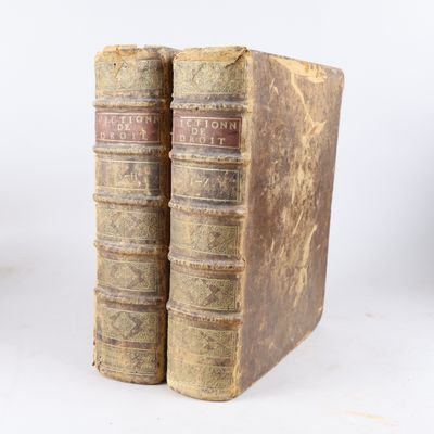 deux vieux livres posés l'un sur l'autre sur une surface blanche