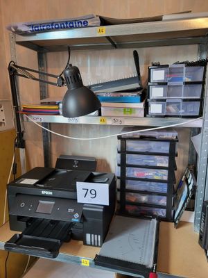 un bureau sur lequel se trouvent une imprimante, ainsi que d'autres fournitures de bureau
