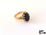 an image of a gold ring with a black stone