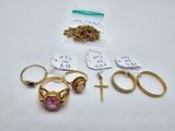 several gold rings and a cross are sitting on a table
