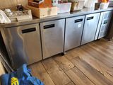 a kitchen with a stainless steel counter top and a blue bag on the floor