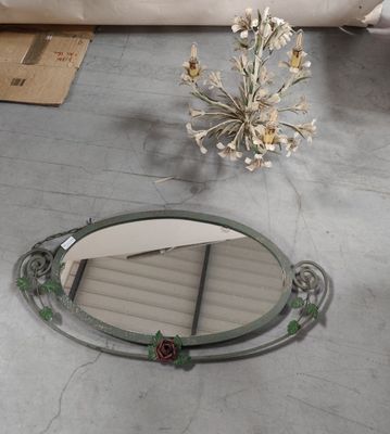 a mirror sitting on the floor next to a vase of flowers