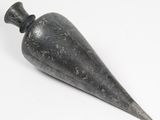 une image représentant un objet en pierre noire posé sur une surface blanche