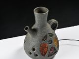 a small vase with a hole in it on a table