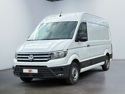 La camionnette blanche est garée dans une pièce blanche au sol noir.