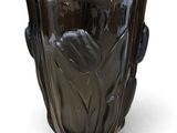 un vase noir posé sur une surface blanche