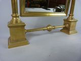 a mirror on a table with a gold frame
