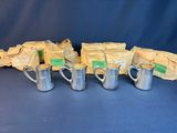 six silver mugs with labels on them sitting on a blue surface