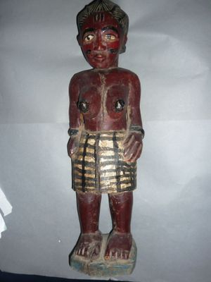 statue en bois représentant un homme portant une jupe et un bandeau