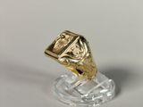 a gold ring on a clear stand on a white surface