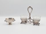 deux plats en métal argenté et une coupe en argent posés sur un plateau blanc