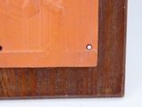 une plaque en bois sur laquelle figure la photo d'un homme