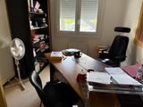a desk with a fan in the corner of the room