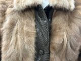 un homme vêtu d'un manteau de fourrure et d'une cravate noire