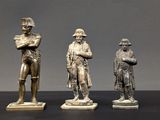 trois figurines en bronze représentant un homme et une femme debout l'un à côté de l'autre
