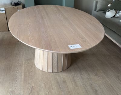 une table en bois avec un piètement en bois dans un salon