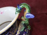 a blue and green vase with a dragon on it